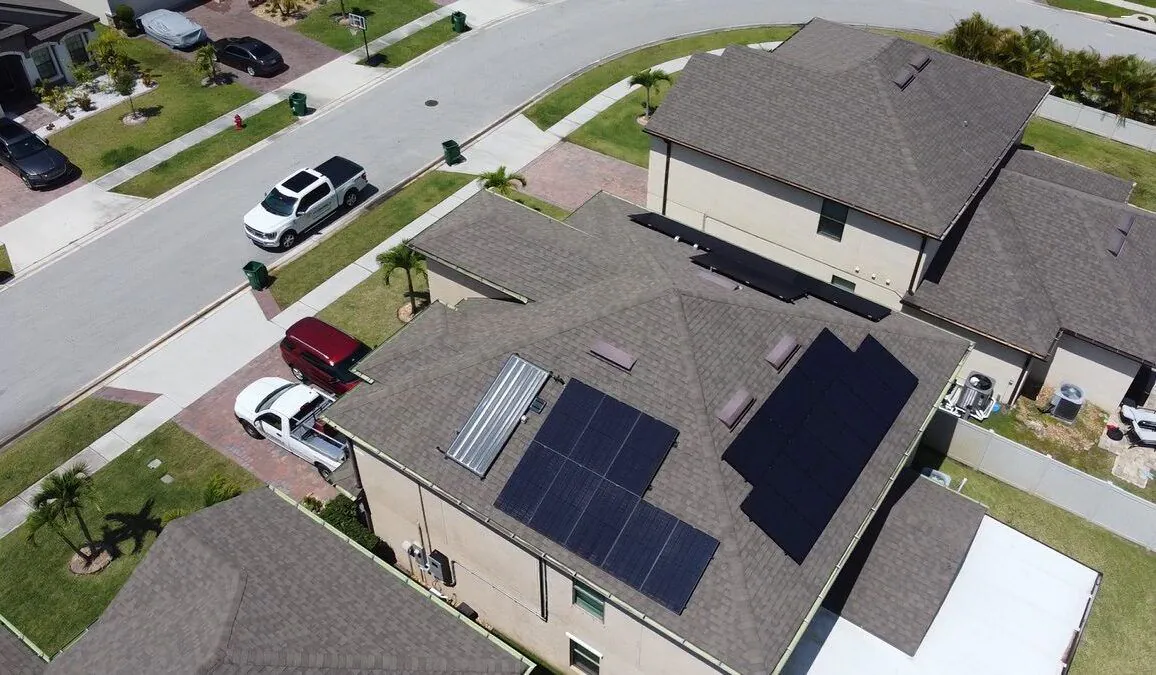 Aerial view of a two-storey home with rooftop solar on a quiet residential street