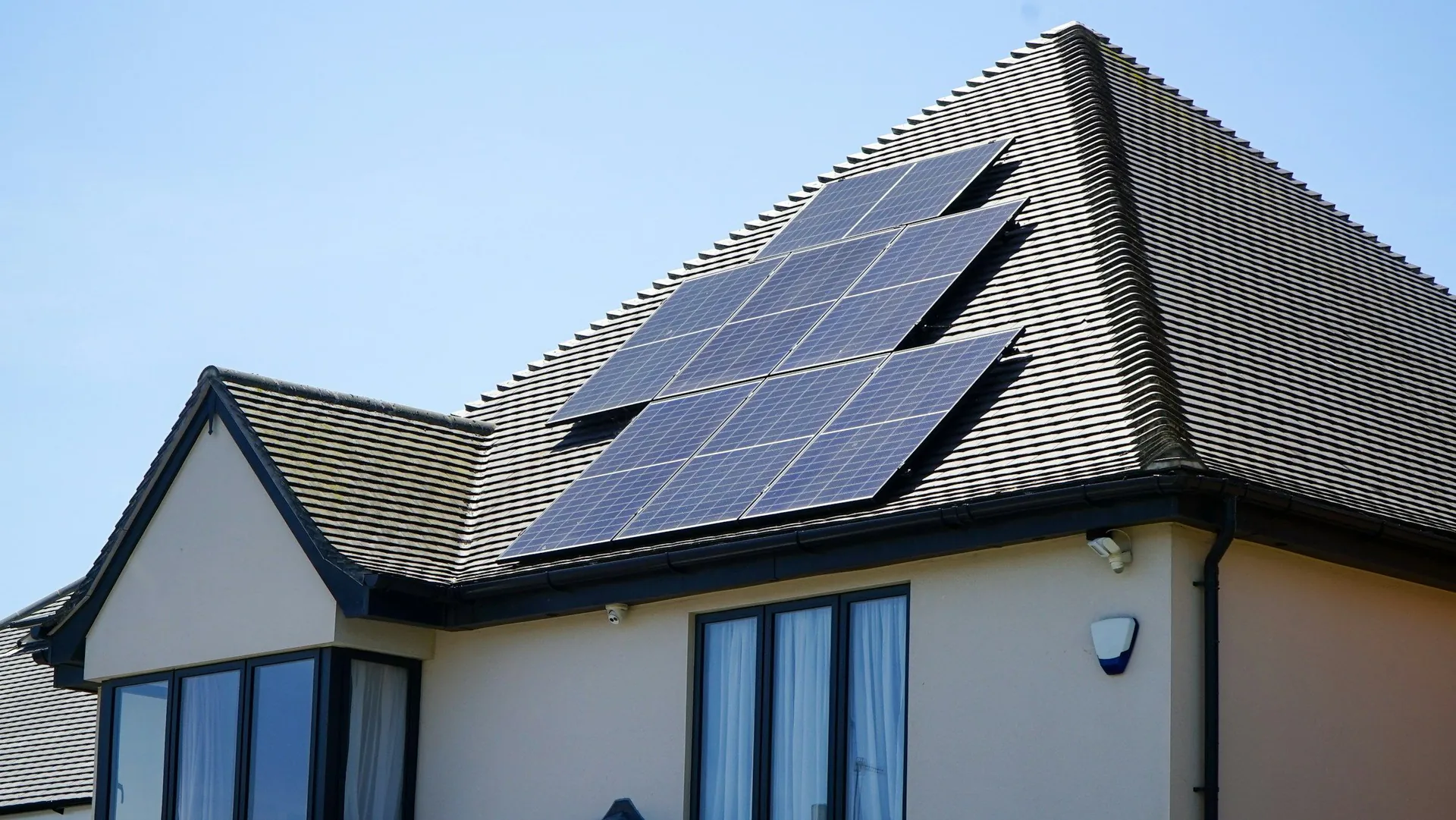 Sunny house exterior with solar panels on the roof