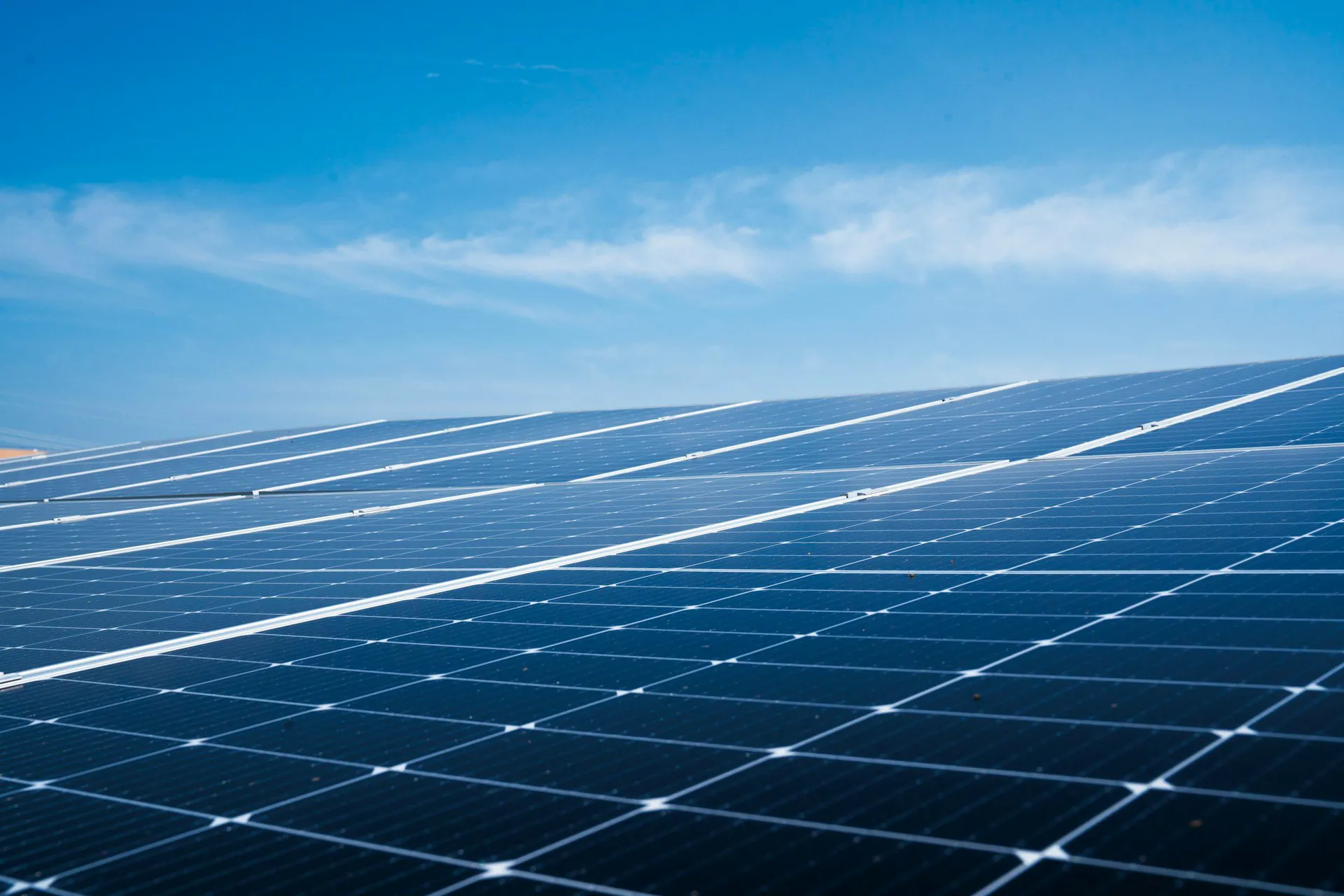 Close-up of blue solar panel cells reflecting a bright sky