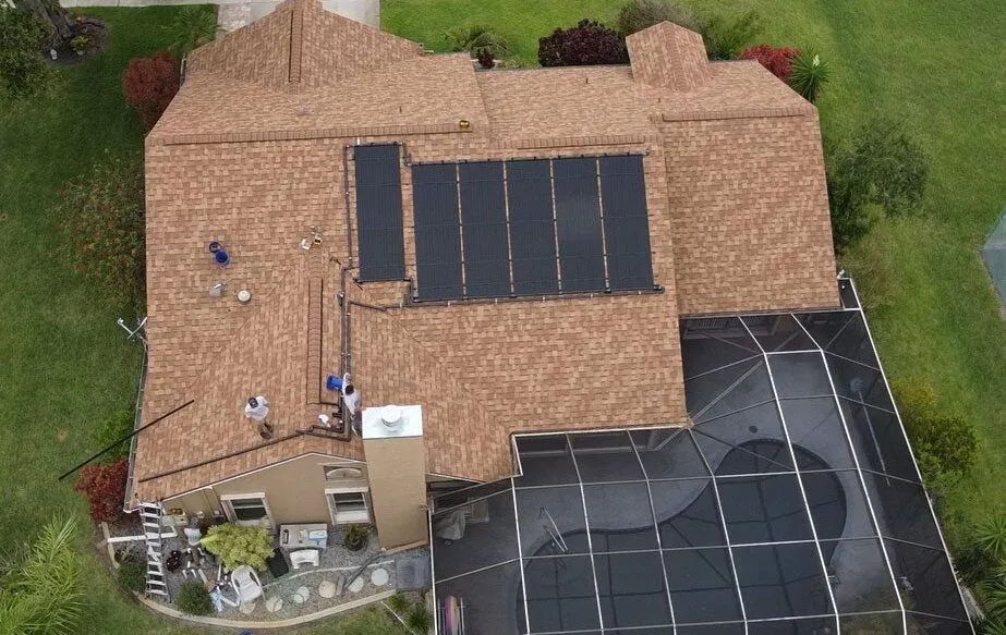Aerial view of a tiled home with solar water heating and solar panels on its roof