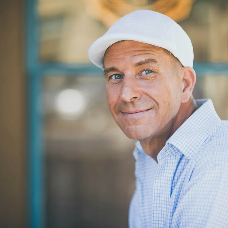 Portrait of Marcus Hale, a smiling man in a white cap and work shirt