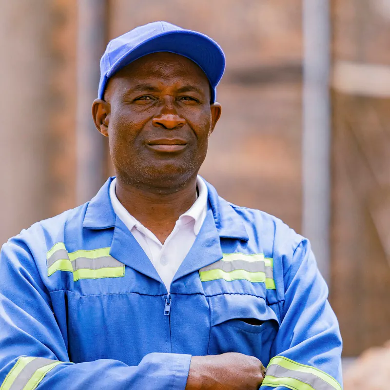 Portrait of Luis Moreno, a man in blue work coveralls and cap